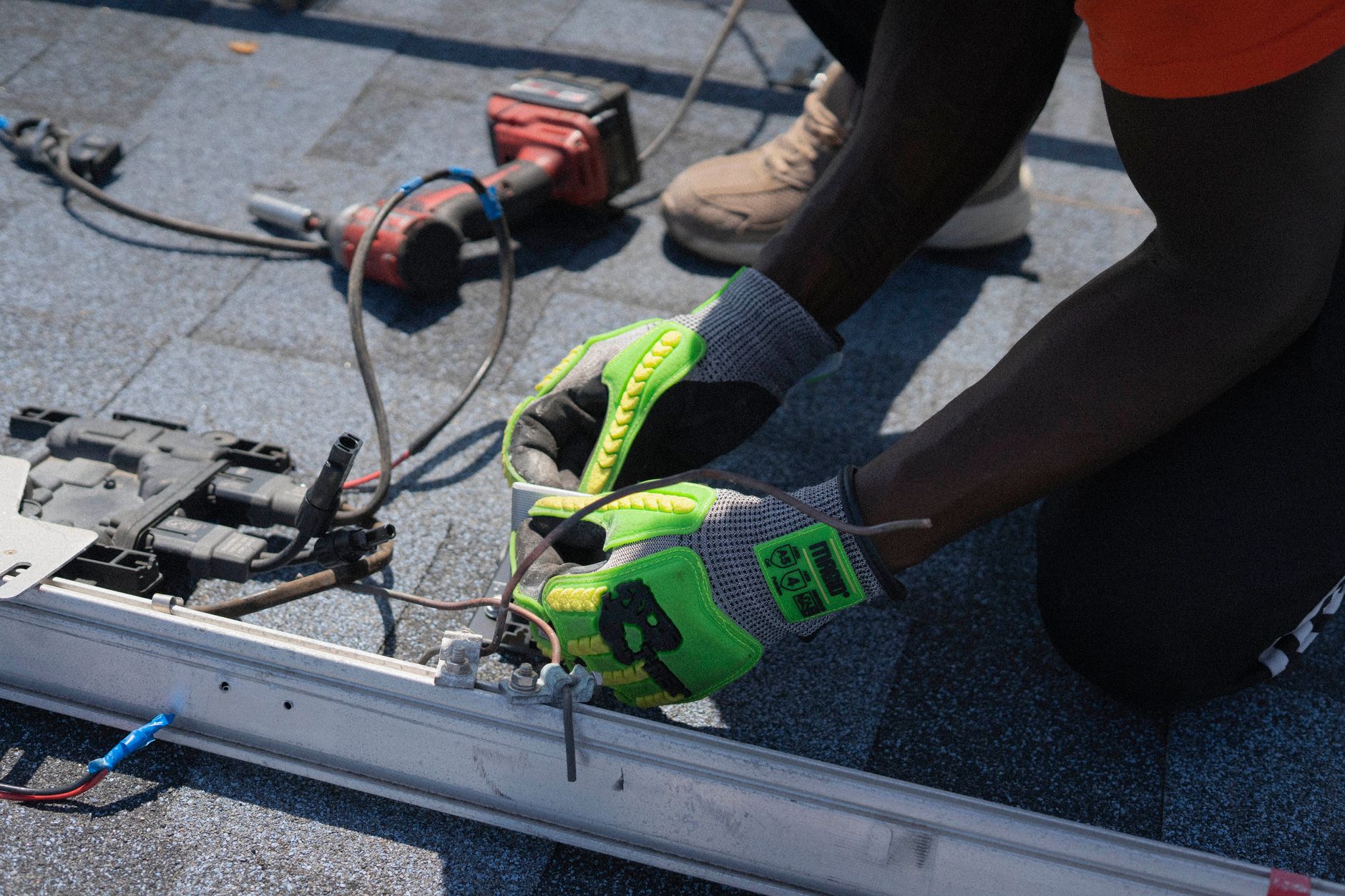 A Tri Peak Roofing crew member meticulously installing UV-resistant shingles on a residential roof in Paradise, Nevada, with the desert landscape in the background.