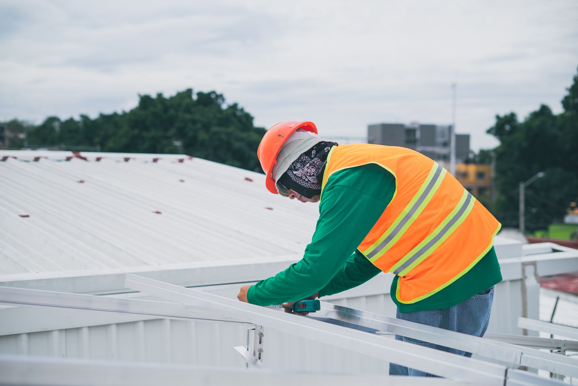 A Tri Peak Roofing crew member safely working on a low-slope roof of a Spring Valley home, ensuring proper valley flashing installation.